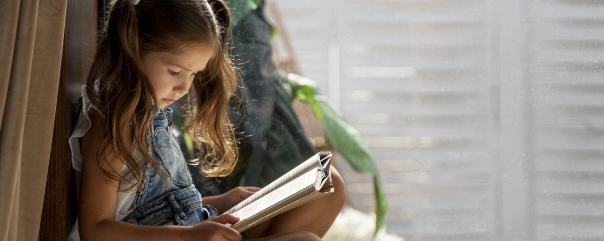 close-up-little-girl-having-fun-home Meisje leest boek 4 - 6 jaar